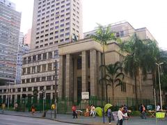 Entrance of Biblioteca Mário de Andrade in São Paulo with people walking and trees surrounding