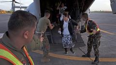U.S. Marines assisting a Filipino woman off an MV-22B Osprey at Villamor Air Base after Typhoon Haiyan