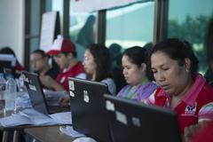 Filipino volunteers and social welfare personnel assisting evacuees from Typhoon Haiyan at Villamor Air Base