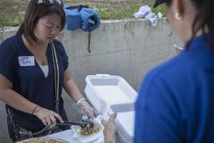 Volunteer serving food to evacuees at Villamor Air Base during Typhoon Haiyan relief operation