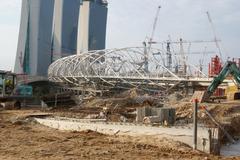 Double Helix Bridge under construction with Marina Bay Sands also under construction in the background