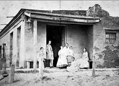 Carlos Pellegrini standing at the entrance of a house in San Isidro in 1866, second from left among a group of men