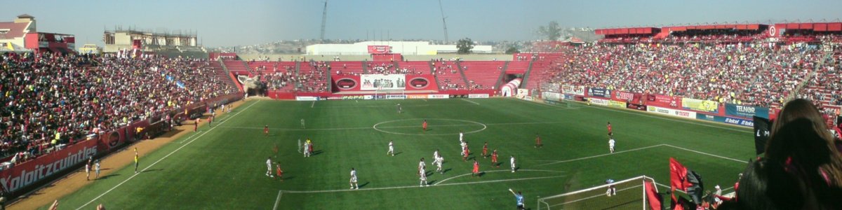 Soccer stadium under construction with steel framework and cranes