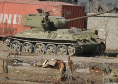 Afghan National Army soldier sitting on a World War II Russian T-34 tank at Forward Operating Base Muqer construction site in Ghazni, Afghanistan