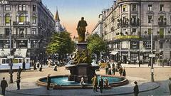 Historical photo of Bahnhofplatz in 1900 showing horse-drawn carriages and early urban life