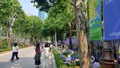 Boramae Park with walking path and tall residential buildings in the background under a partly cloudy sky