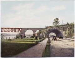 Historic photochrom postcard of a riverside town with boats and early 20th-century buildings