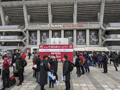 Waseda University Ekiden team running in rainy conditions at Yokohama Nissan Stadium