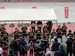 Waseda University Ekiden team running in rain at Yokohama Nissan Stadium