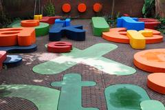 Outdoor playground with geometric climbing structures and slides at Museum Meermanno