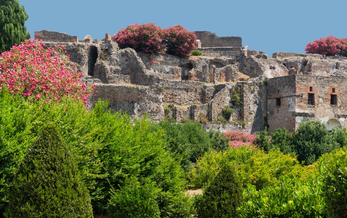 Ruined ancient buildings in Pompeii with stone walls and open courtyards