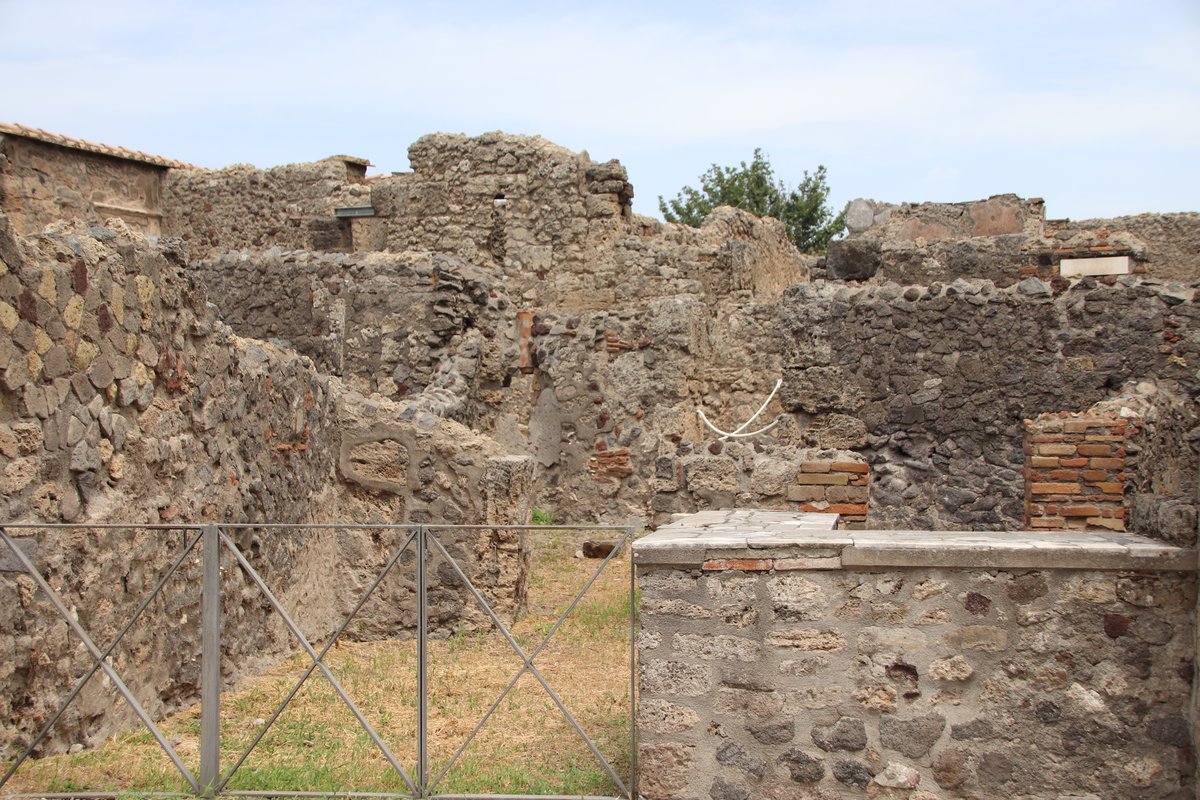 Exterior of Taberna Phoebi, an ancient shop in Pompeii, showing a historic Roman stone facade