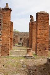 Ruins of Casa del Forno VI.3.3 in Pompeii with ancient stone walls and scattered debris under clear blue sky