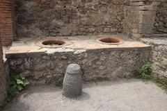 Ancient Roman thermopolium in Pompeii with counter and frescoes
