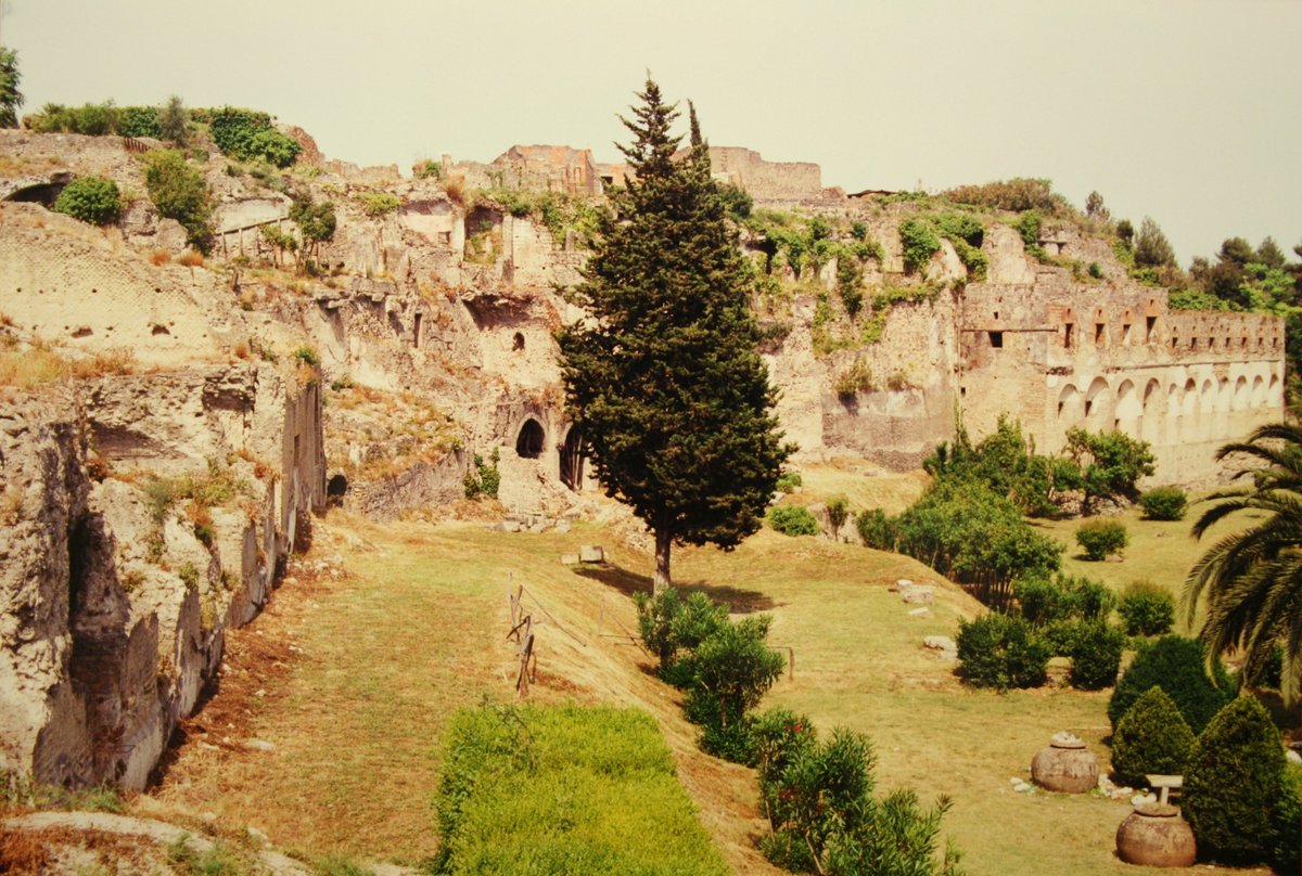 Ruins of ancient Pompeii city with preserved walls and archways under blue sky