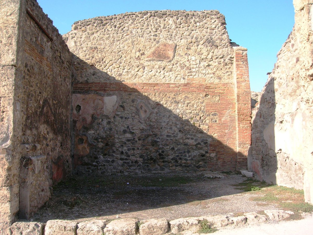 Ancient Roman shop interior in Pompeii with masonry walls and stone floor