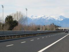 Highway A23 near Udine Sud in Italy with cars and trucks on the road and a green landscape