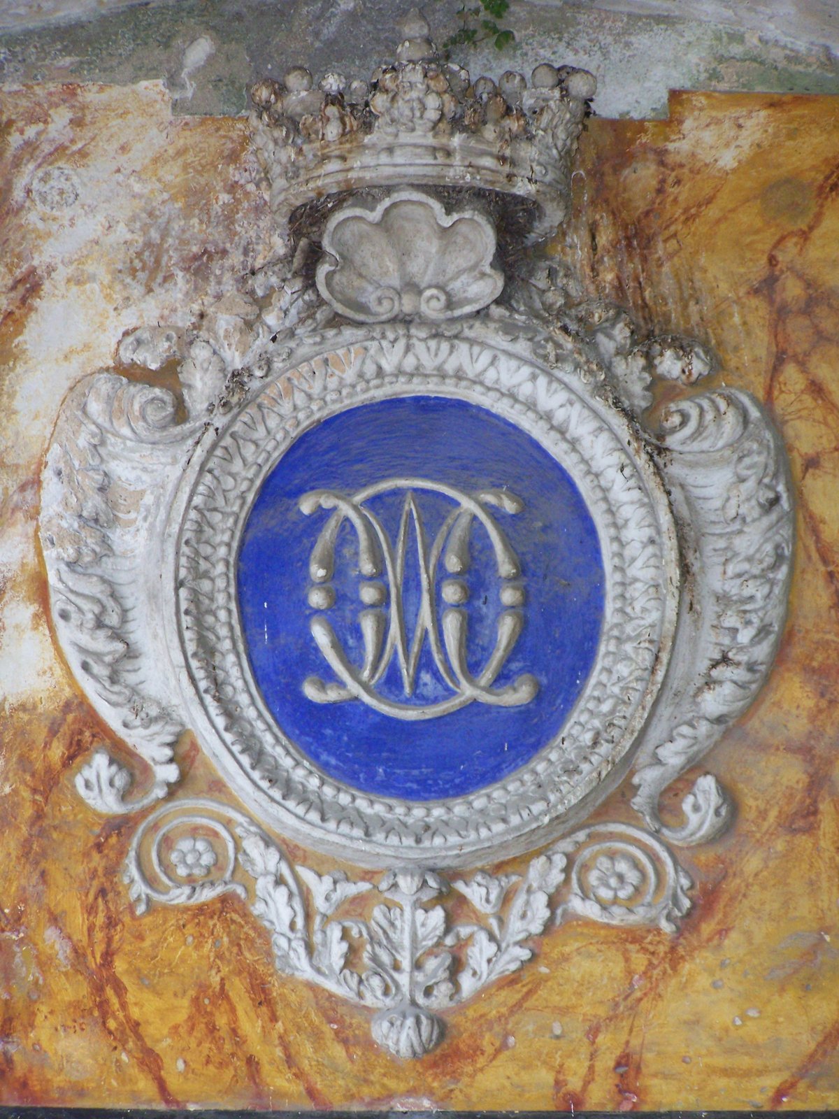 Stucco with coat of arms of the Oblates of Mary Immaculate above the entrance door to Saint-Pons Abbey church in Nice, France