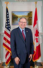David L. Cohen, United States Ambassador to Canada, posing outdoors at Lornado residence in fall attire with autumn foliage in background