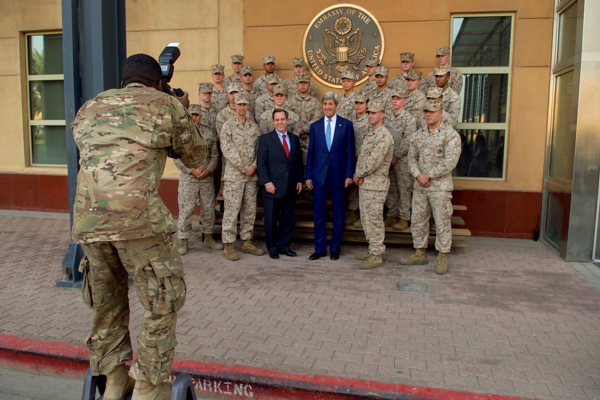 Marine Corps photographer taking photo of U.S. Secretary of State John Kerry and U.S. Ambassador Stuart Jones with Marine Security Guard members in Baghdad