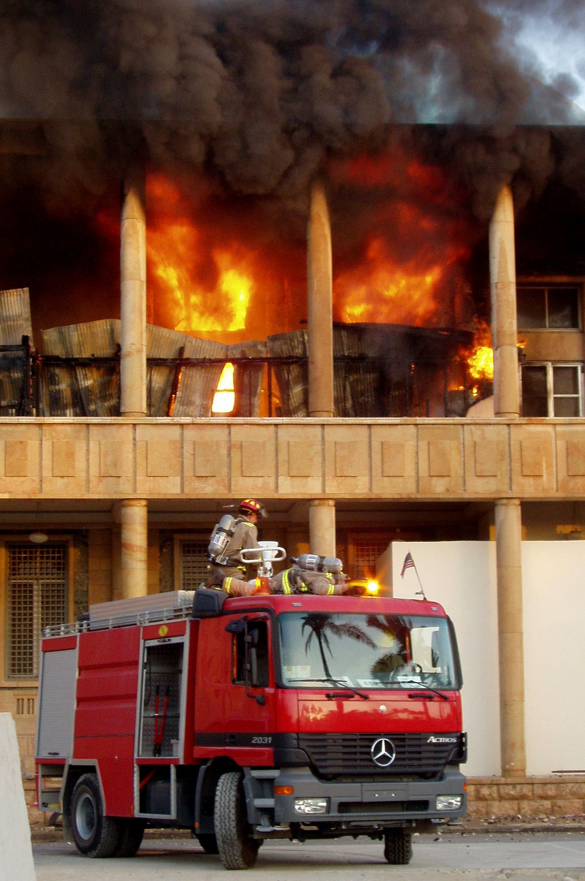 Firefighters with SCBA gear responding to a fire at the US embassy in Baghdad, Iraq with a Mercedes Benz Actros 2031 fire engine