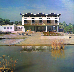 View of the US Embassy in Baghdad in 1961 with surrounding palm trees and vehicles