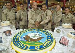 Senior and junior sailors cutting cake during US Navy 233rd birthday celebration at U.S. Embassy Baghdad