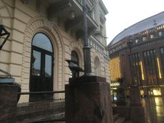 Crow sitting on a pedestal outside the entrance to the old student house in Helsinki