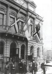 Half-mast flags of Ingria, Finland, and East Karelia on the pediment of the Old Student House in Helsinki as a protest against deportations from Ingria and East Karelia, Autumn 1934