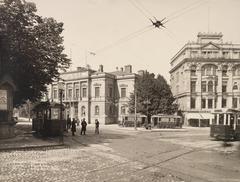 Intersection of Itäinen Heikinkatu (now Mannerheimintie) and Vladimirinkatu (now Kalevankatu) in 1900 with trams, kiosk with Kullervo advertisement, old student house and Tallberg building with Photographer IRIS sign