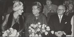 Queen Juliana and Minister Marga Klompé receiving flowers at the 50th anniversary congress of the Council for Social Welfare in Circustheater Scheveningen, 1968