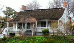 Historic farmhouse viewed from Broadway under cloudy midday sky