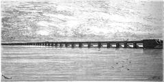 Victoria Bridge over a river with urban buildings in background