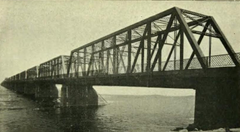Pont Victoria bridge in Montreal with boats passing on the water