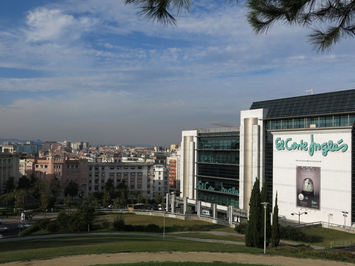 Red trams on a street in Lisbon with colorful buildings and a clear blue sky