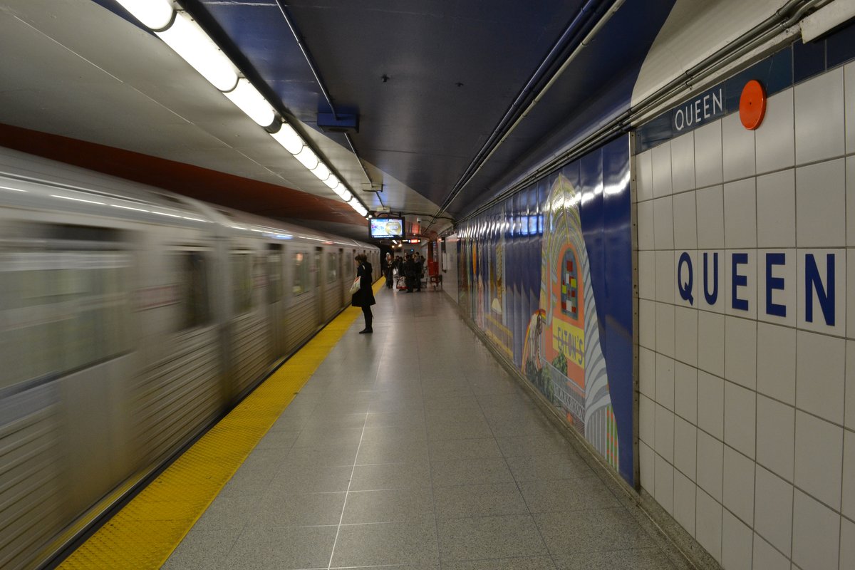 Queen Subway Station platform with signage and seating