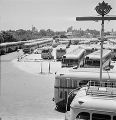 Buses parked at the depot in Tel Aviv on Sabbath with Trans World Airlines building in the background