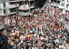 Revelers at Asan Square wearing colorful caps during Dyah Lwakegu festival with three portable shrines
