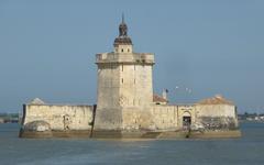 Fort Louvois facade seen from the coastal pier at low tide with stone causeway access