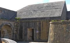 Stone powder magazine building at Fort Louvois with thick walls and stone roof