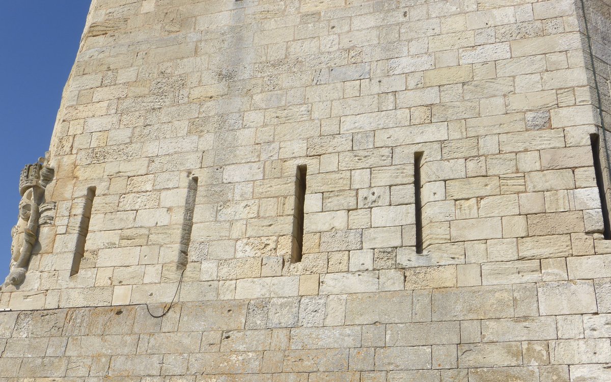 Bourcefranc Fort Louvois donjon with royal coat of arms carved above five archers' loopholes under a cloudy sky