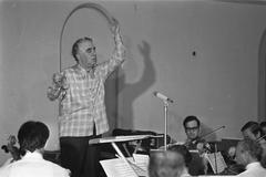 Composer Aram Khachaturian conducting the Amsterdam Philharmonic Orchestra during rehearsal at Felix Meritis in Amsterdam, 1971