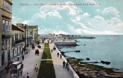 Habana street view with classic cars and Castillo la Punta in the background