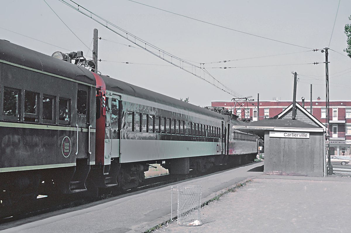 Canadian National Electric Multiple Unit suburban train cars in two paint schemes at Cartierville stop in Montreal