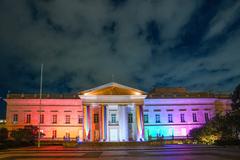 LGBTIQ month commemoration event with a speaker at a microphone and colorful backdrop