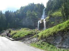 Waterfall of Le Rouget flowing through rocky terrain surrounded by lush green forest near Sixt-Fer-à-Cheval in Haute-Savoie, France