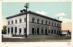 Front view of the United States Mint building with prominent columns and American flags