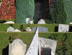 A peaceful cemetery with rows of headstones and green grass under a clear blue sky