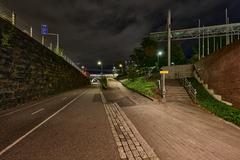 Baana pedestrian and cycling path in Helsinki illuminated at night with city buildings and lights