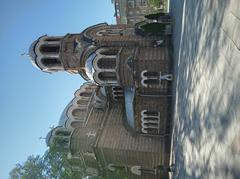 Exterior view of Seven Saints Church in Sofia with distinctive pink and white facade under a clear sky